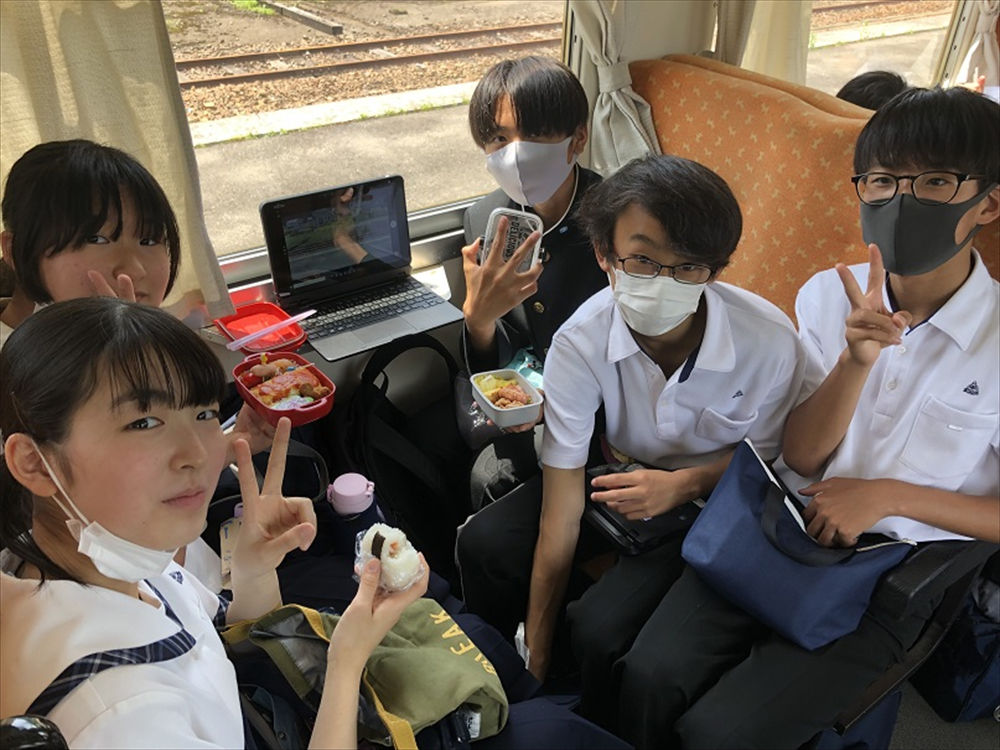 写真:鉄道内で昼食を食べる生徒
