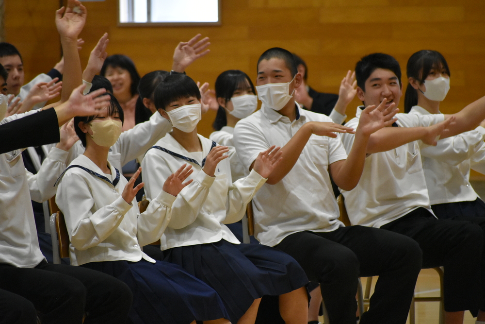 写真:演奏に合わせて手を振る生徒