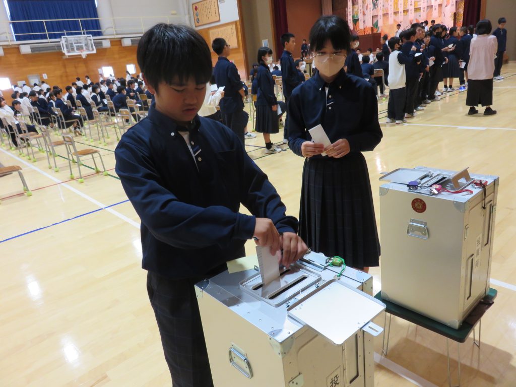 写真*本物の投票箱に投票をする生徒