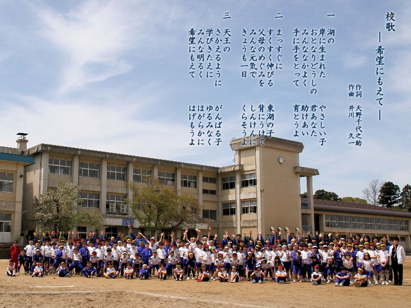写真:校舎と児童を背景にした校歌の歌詞画像